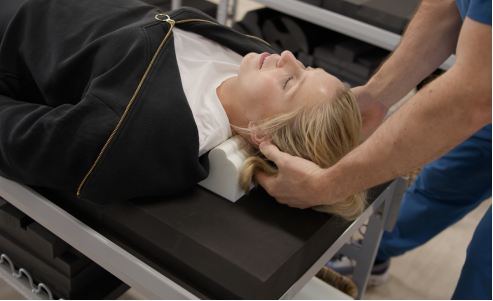 A female patient lies on a chiropractic table.