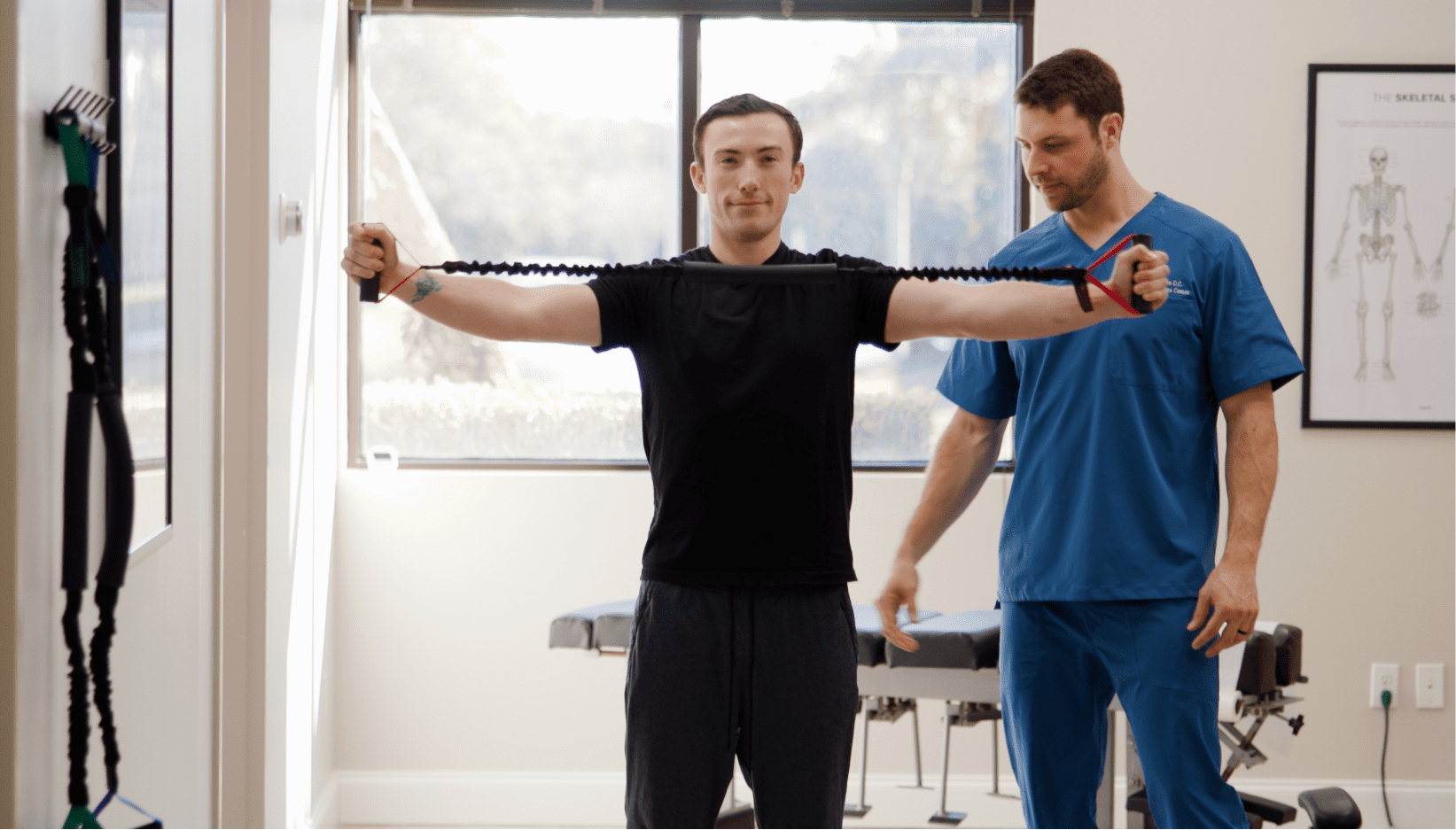 A patient stretching his arms with a chiropractic equipment