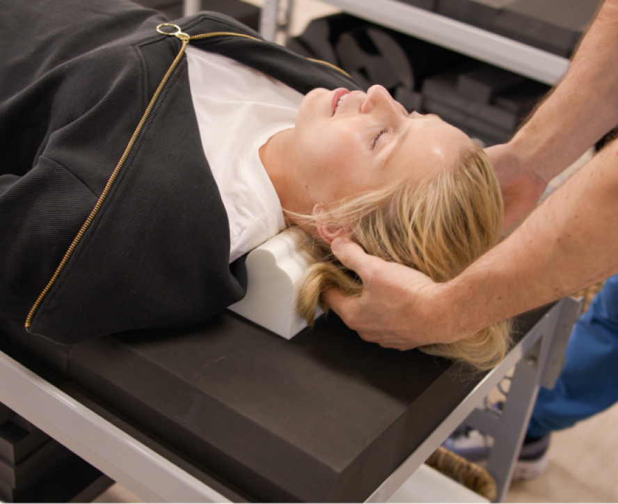 A female patient lies on a chiropractic table. for treatment.